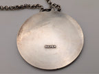 Silver round pendant back with 'SILVER' hallmark and chain link