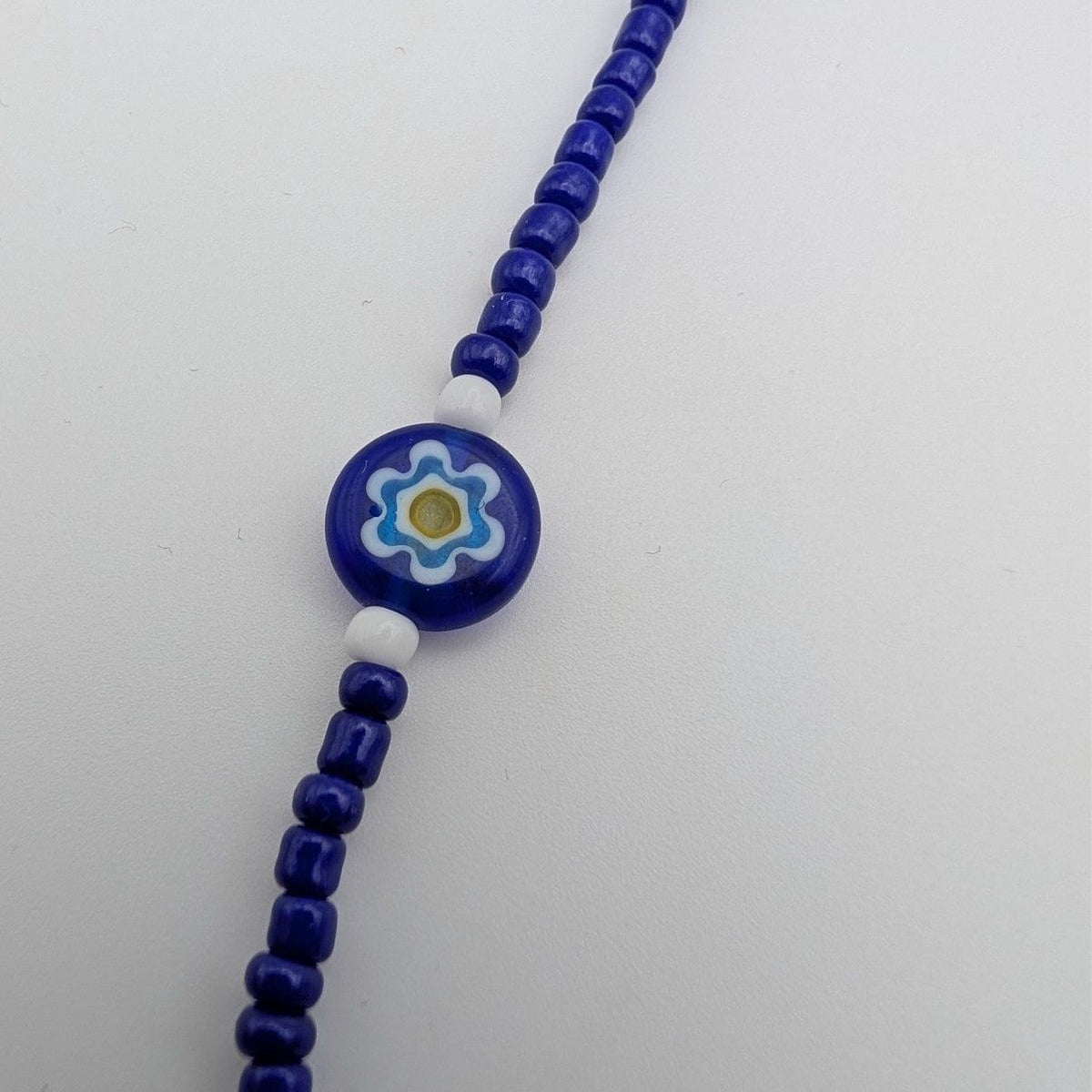 Blue beaded choker with round blue flower bead detail