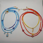 3-piece glass beaded necklace set laid out: blue and red strands with turtle and seahorse