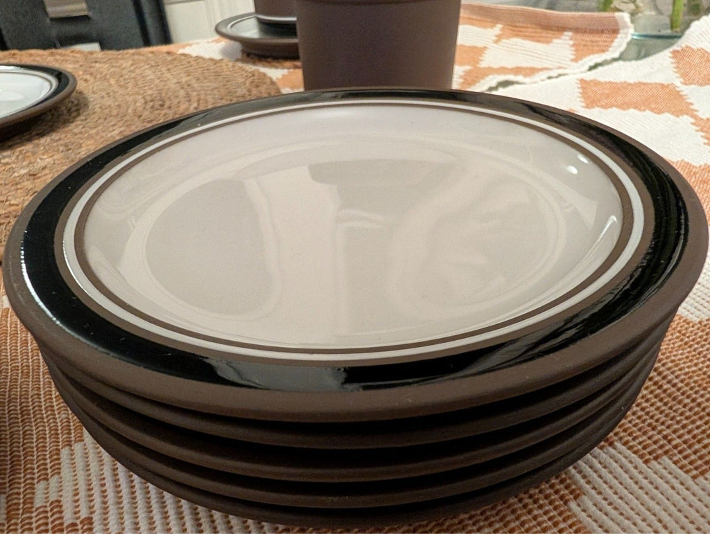 Stack of contrast stoneware saucers with dark rim and white centers