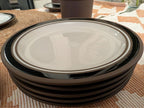 Stack of contrast stoneware saucers with dark rim and white centers