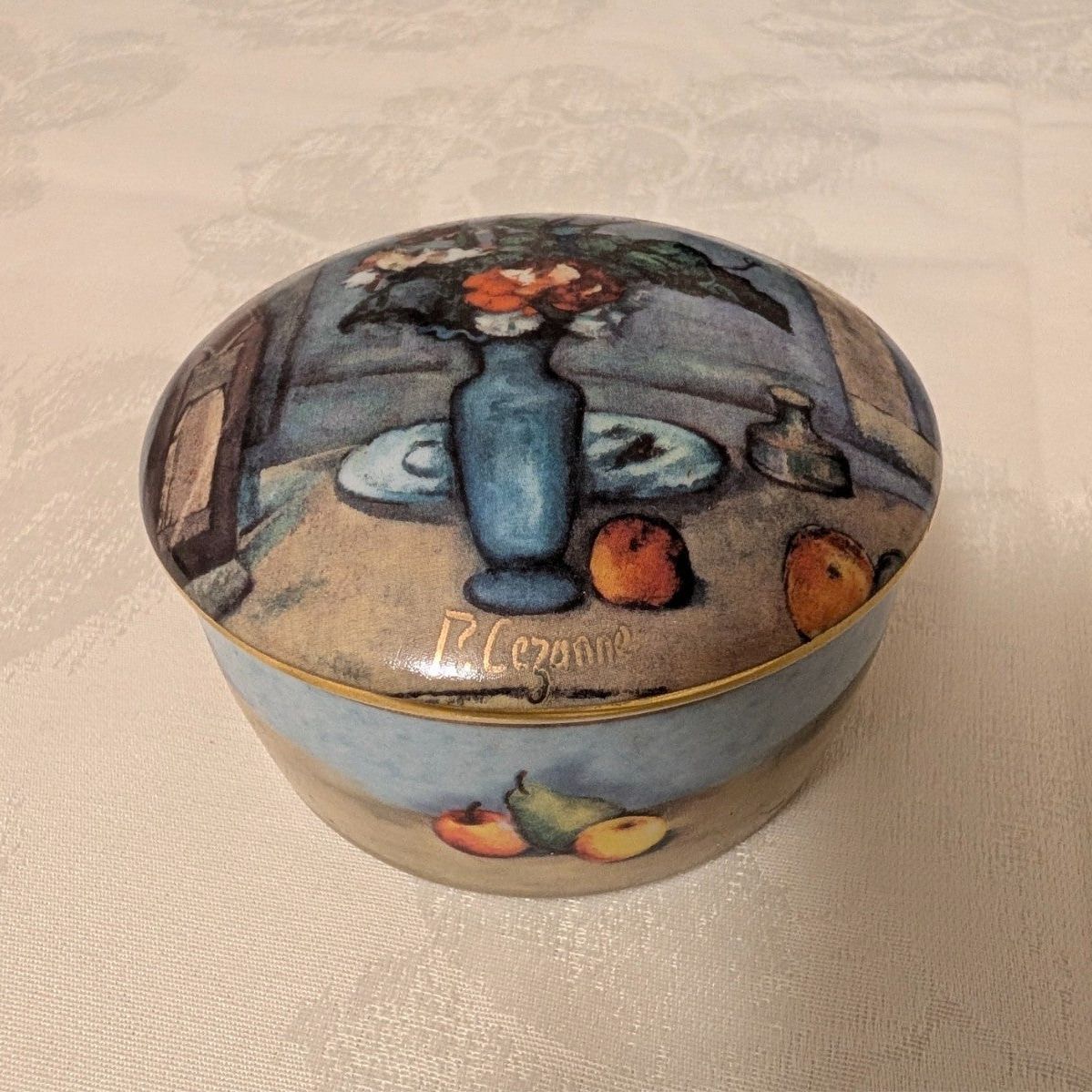 Porcelain trinket box with blue vase and fruit still-life on round lid