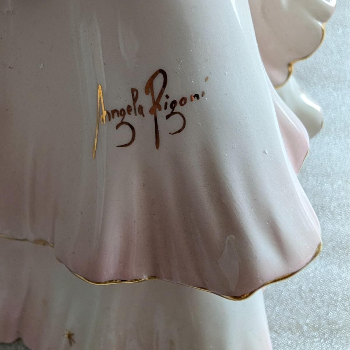Close-up of signed porcelain flamenco dancer skirt with Angela Rigoni signature in gold