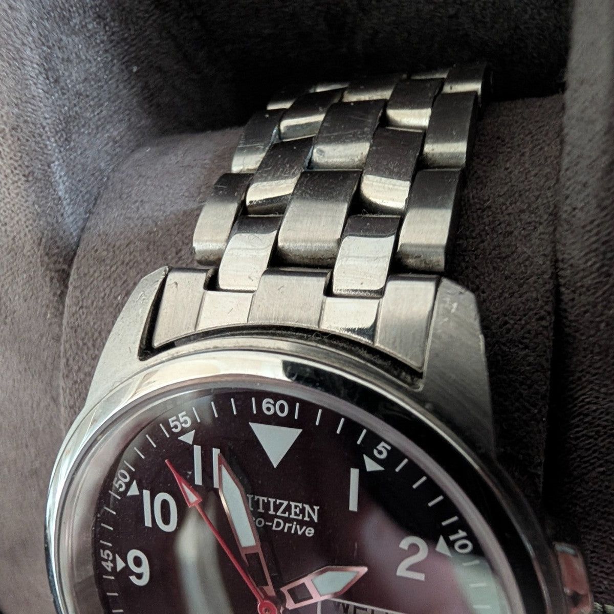 Military style watch dial close-up, Citizen Eco-Drive text with red accents