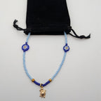 Light blue beaded turtle choker with black cord tie and gold turtle pendant