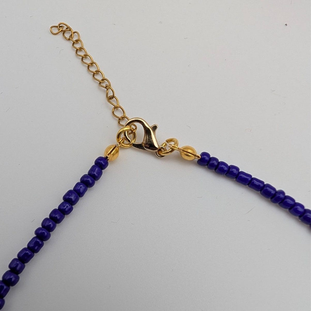 Gold chain clasp end of a blue glass beaded choker