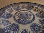 Round blue-and-white dinner plate with floral filigree border and central medallion