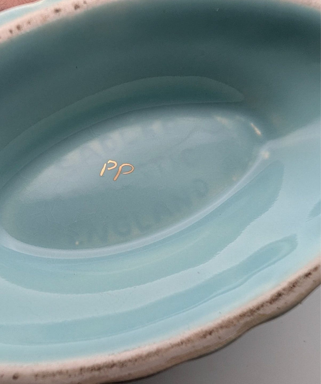 Oval bowl interior with glossy iridescent finish, blue-green glaze
