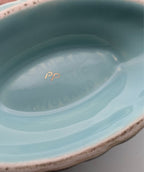 Oval bowl interior with glossy iridescent finish, blue-green glaze