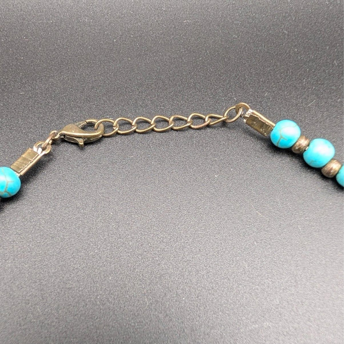 Bronze chain clasp with turquoise bead ends on multi-strand beaded choker
