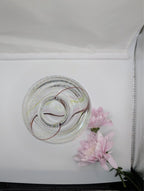 Clear glass bud vase with internal swirl and pink blossoms, side angle