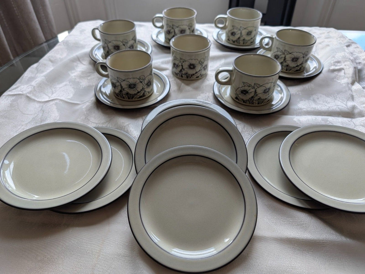 Stoneware tea and coffee set pieces: patterned mugs, saucers, and matching plates