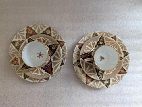 Porcelain cups and saucers, top view, ornate geometric border and floral accents