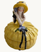 Yellow porcelain lady trinket box with Art Deco style hat and ruffled skirt
