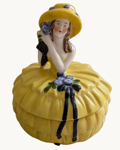 Yellow porcelain lady trinket box with Art Deco style hat and ruffled skirt