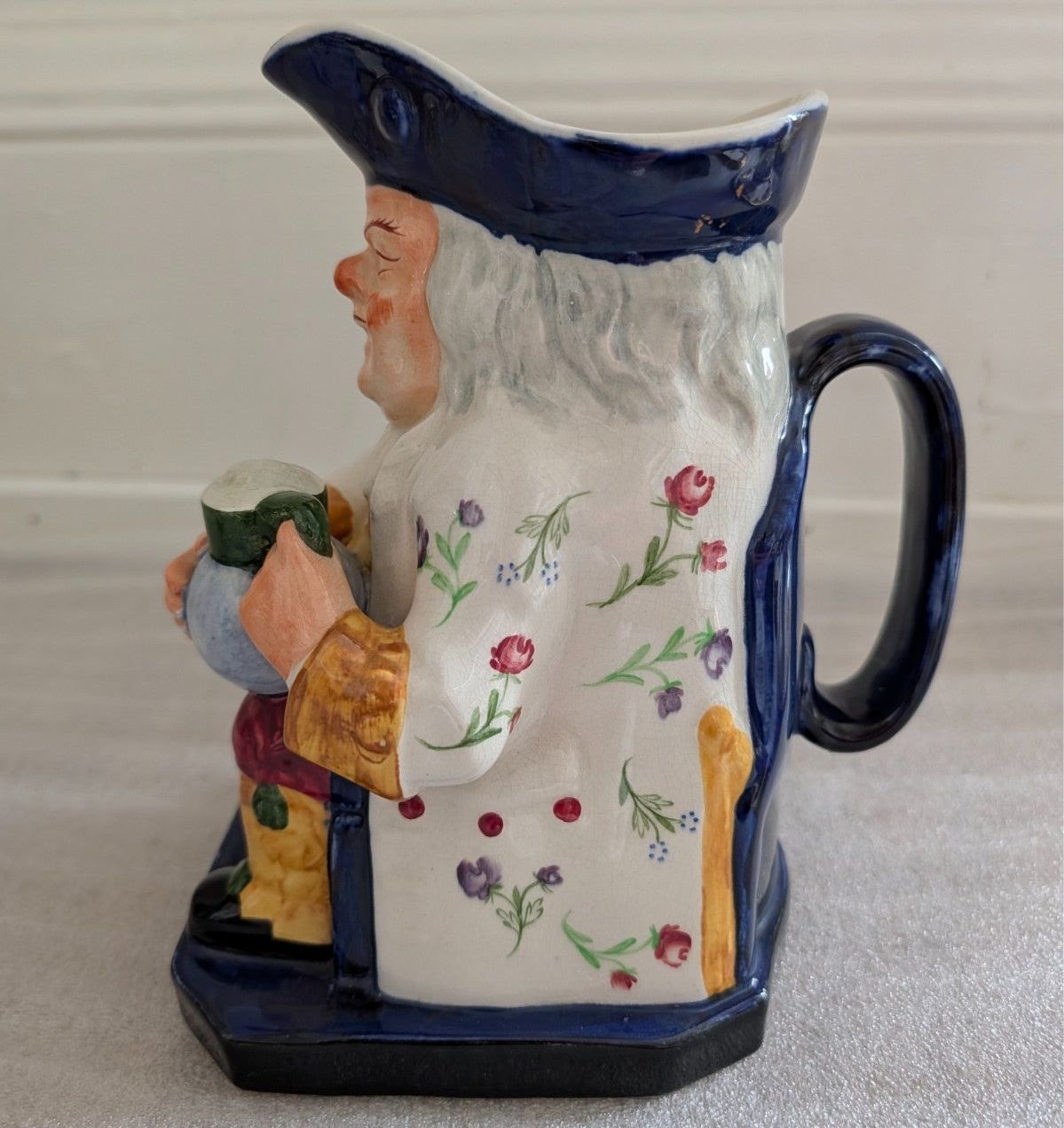 Spode Toby jug character pitcher, side view with floral panel and dark blue handle