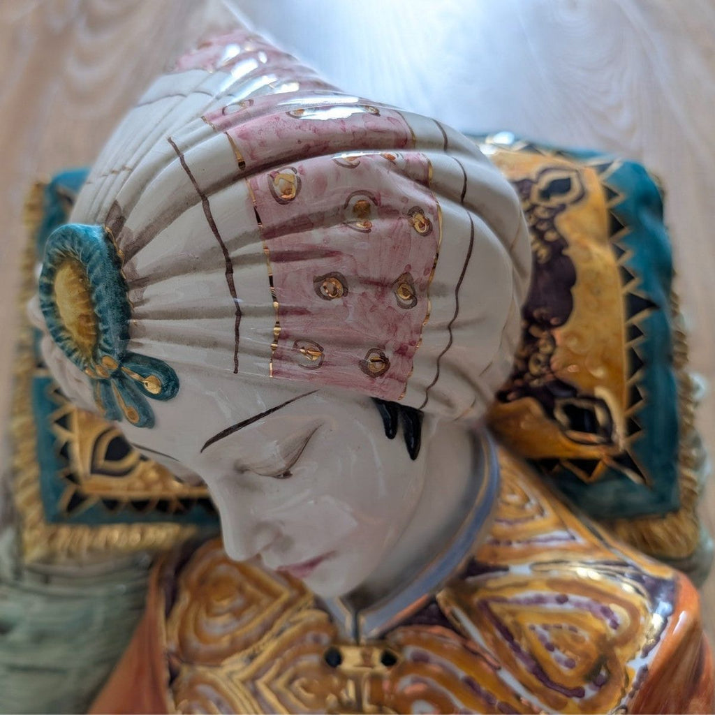 Close-up of porcelain sultan figurine face with painted turban and gold decorative trim