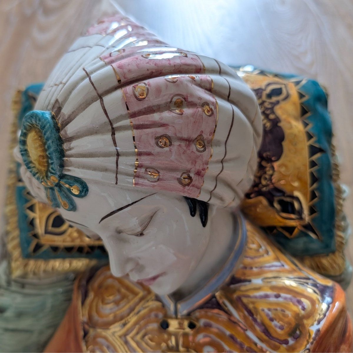 Close-up of porcelain sultan figurine face with painted turban and gold decorative trim