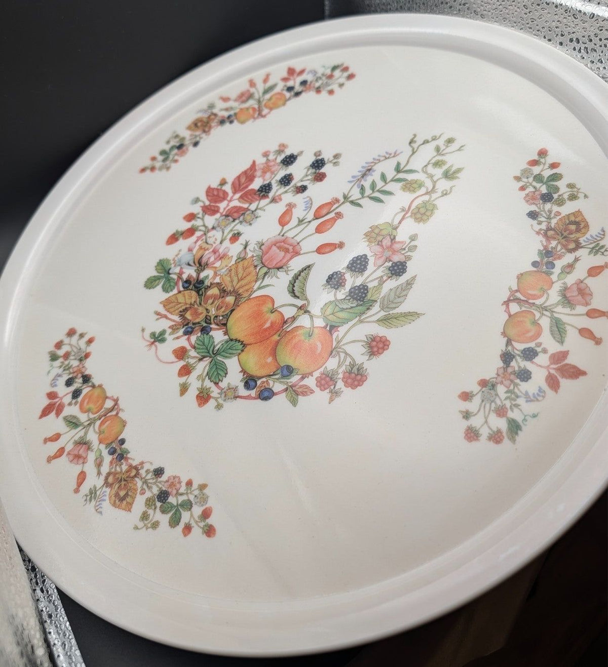 Round white melamine tray with fruit-and-flower wreath border, side angle