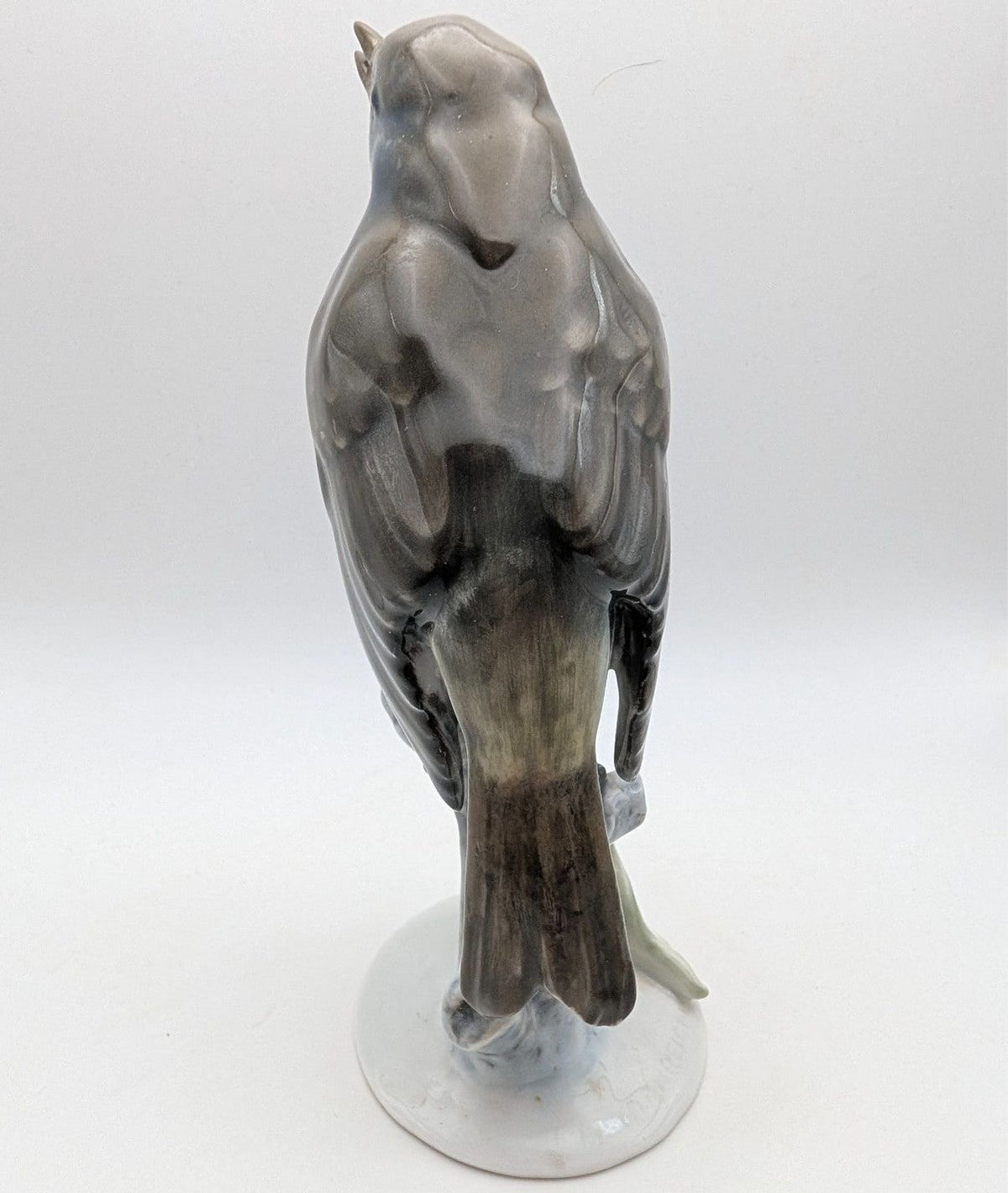 Hand-painted porcelain robin bird figurine from behind, gray feathers with orange tail patch on base