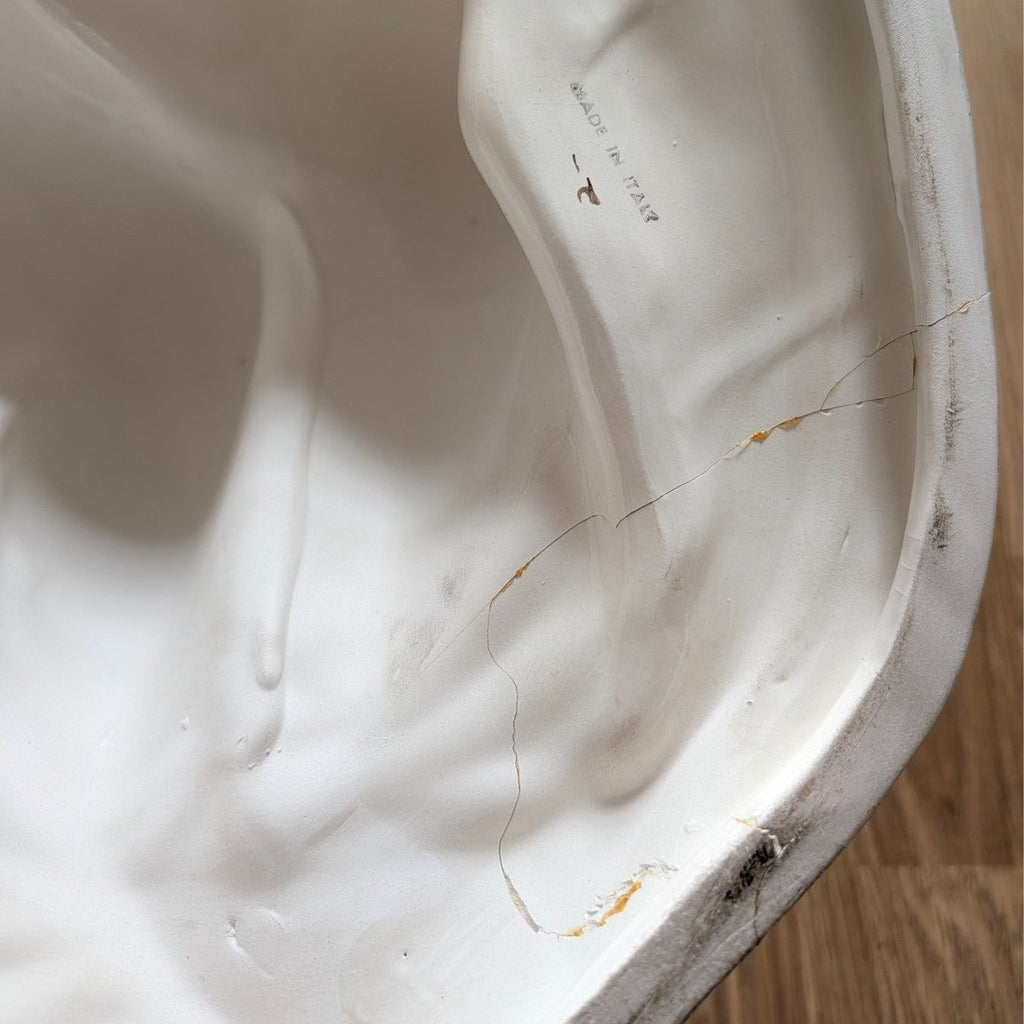 Porcelain underside with faint stamp marks and small worn chips on the edge