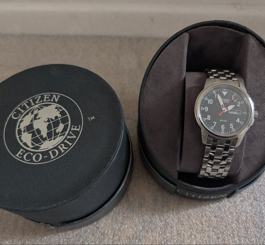 Military style watch in black case, dark dial and steel link bracelet
