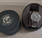 Military style watch in black case, dark dial and steel link bracelet