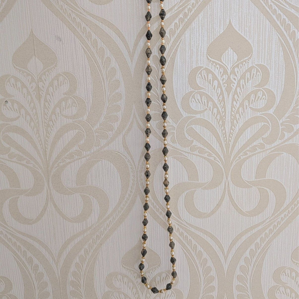 Long opera necklace with grey speckled bead strands and pearl-like bead details