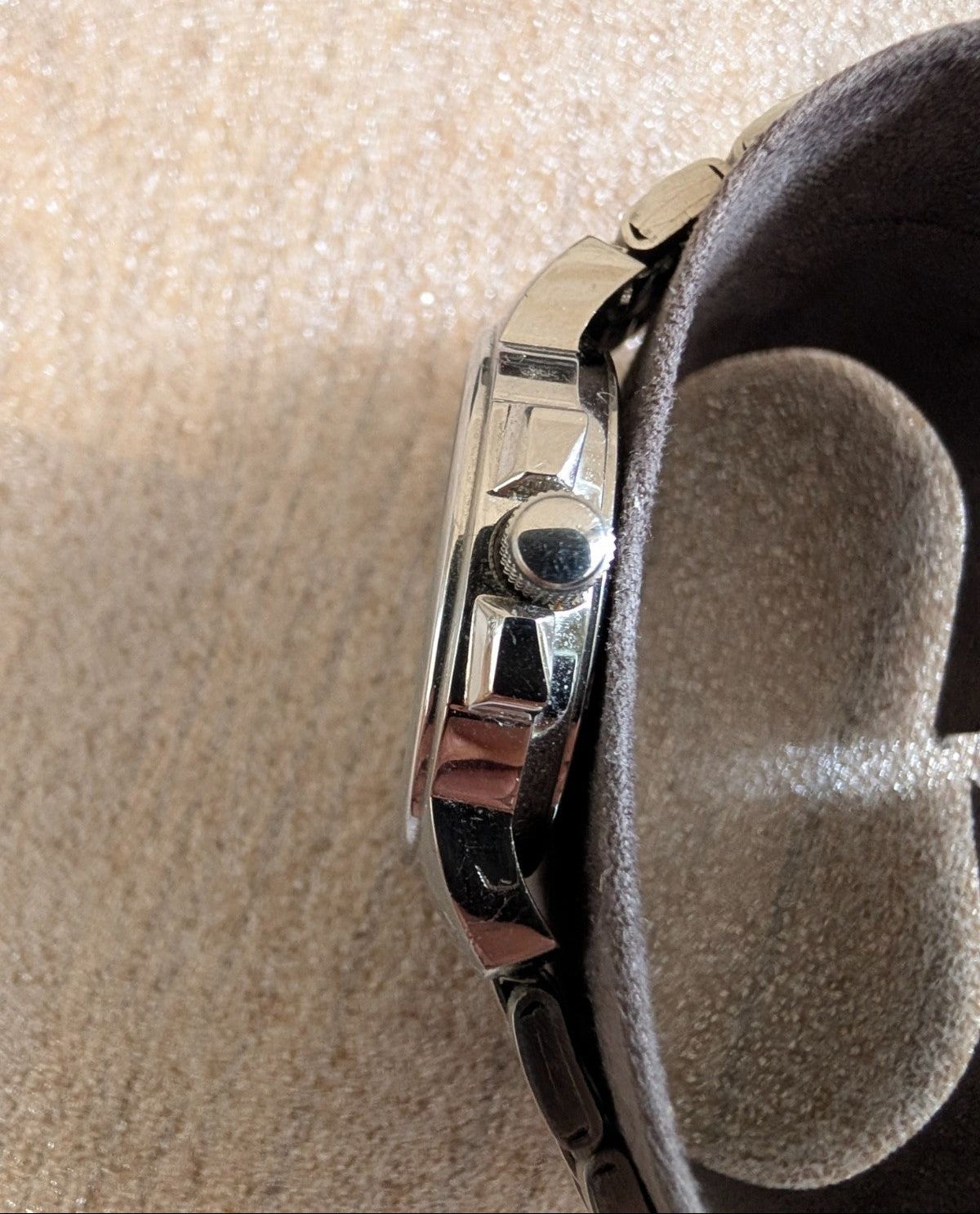 Military style watch back side close-up, polished case detail and crown