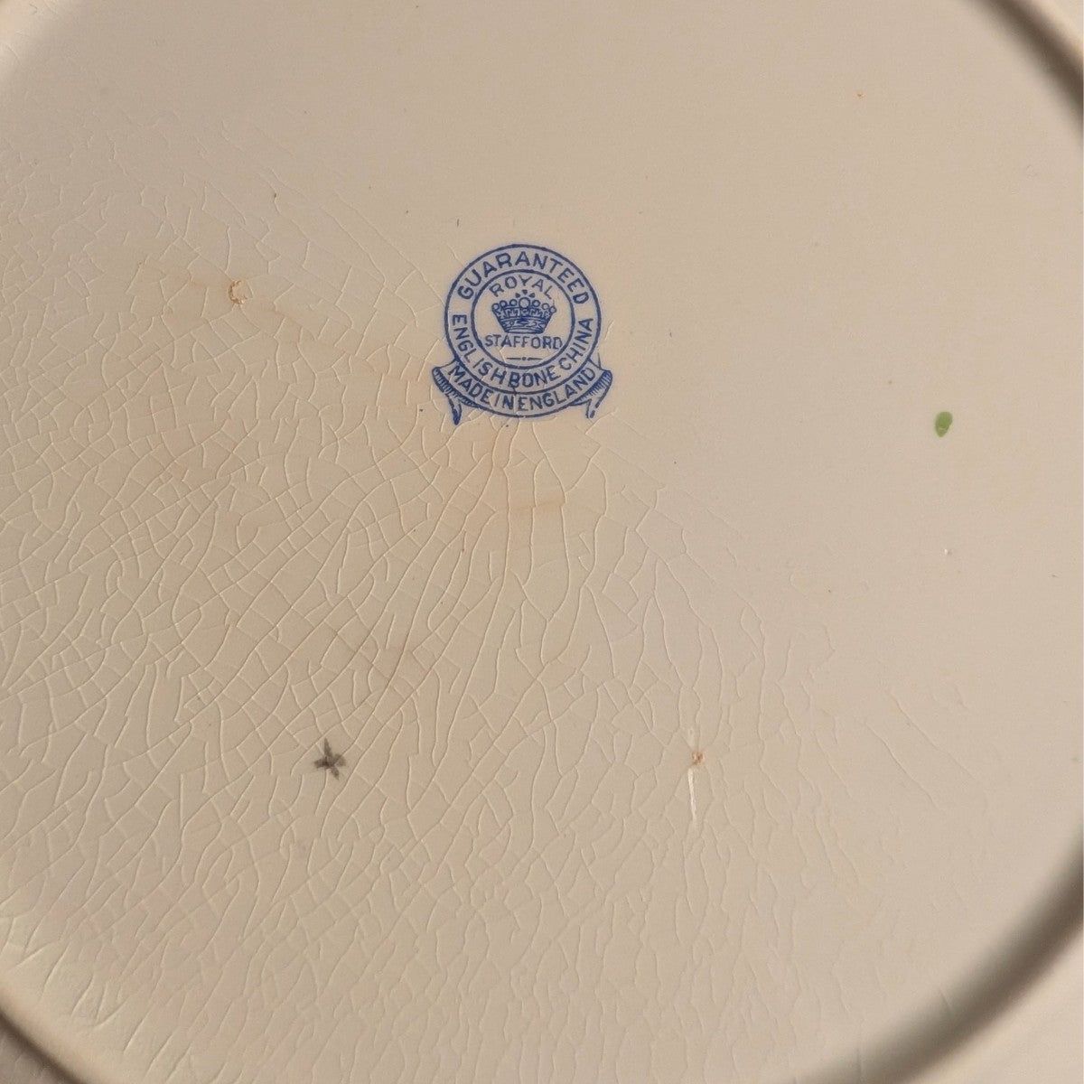 Bone china plate base with blue maker stamp and embossed texture