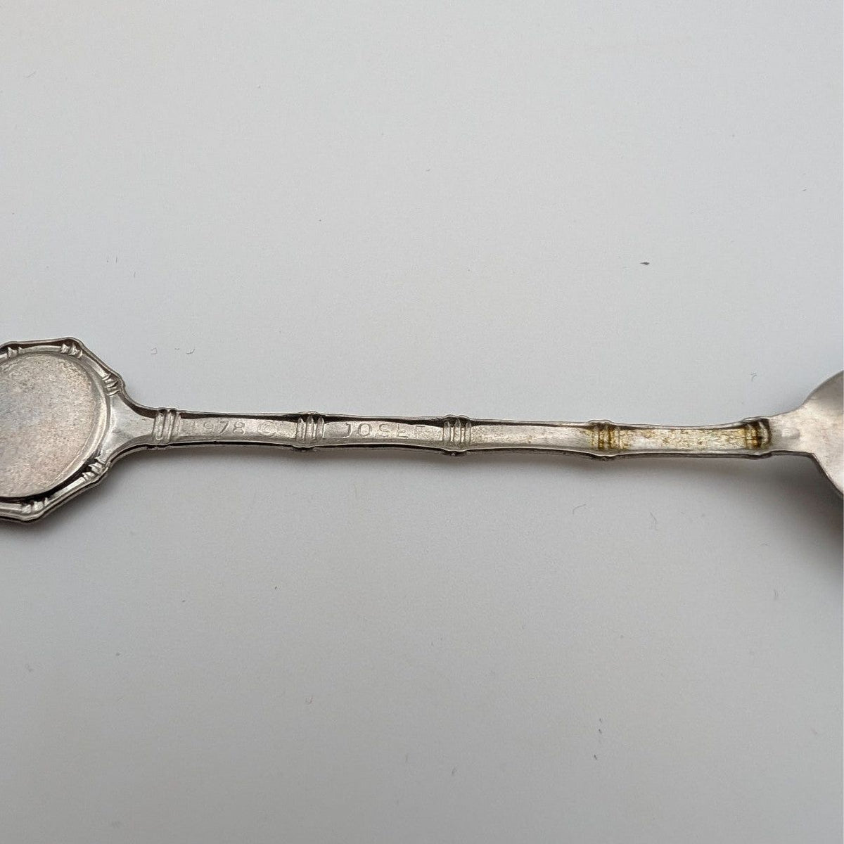 Silver collector spoon handle with banded grip and gold-toned edge