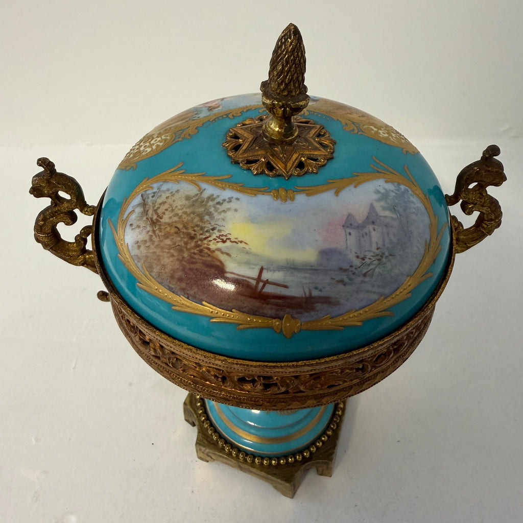 Blue porcelain urn with gilt bronze handles and landscape scene under lid