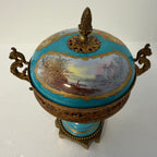 Blue porcelain urn with gilt bronze handles and landscape scene under lid