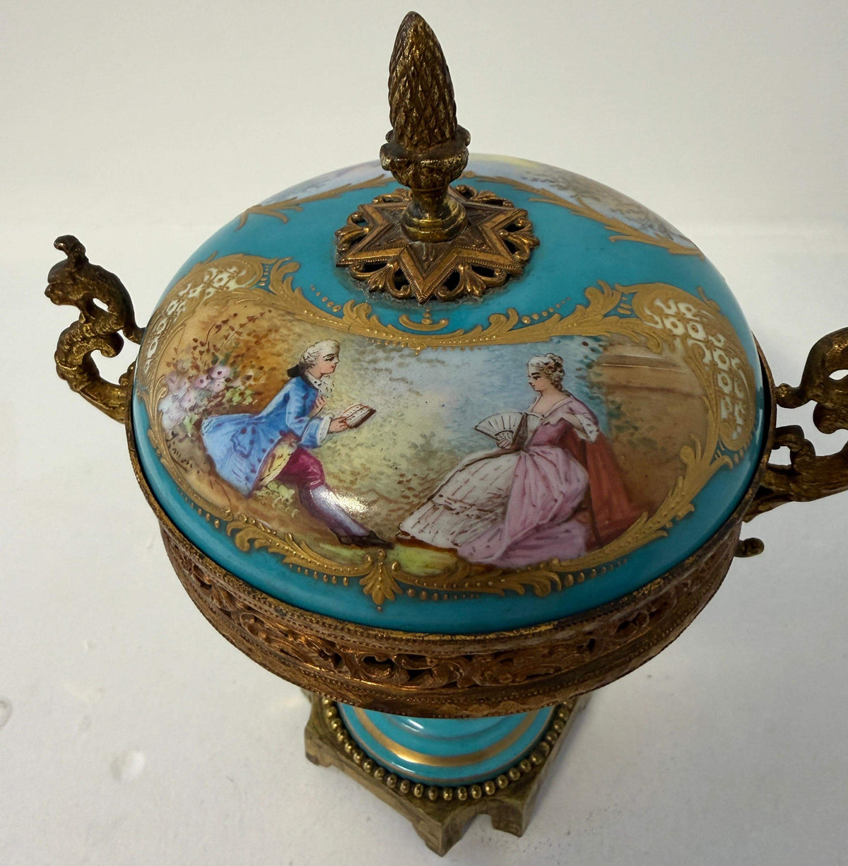 Blue porcelain urn with gilt bronze lid finial and painted court scene
