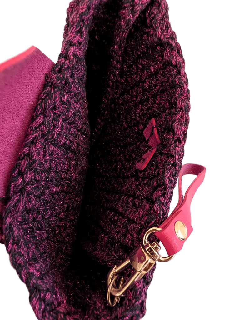 Metallic crochet wristlet clutch close-up: pink strap with gold clasp and dark interior