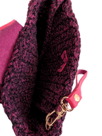 Metallic crochet wristlet clutch close-up: pink strap with gold clasp and dark interior