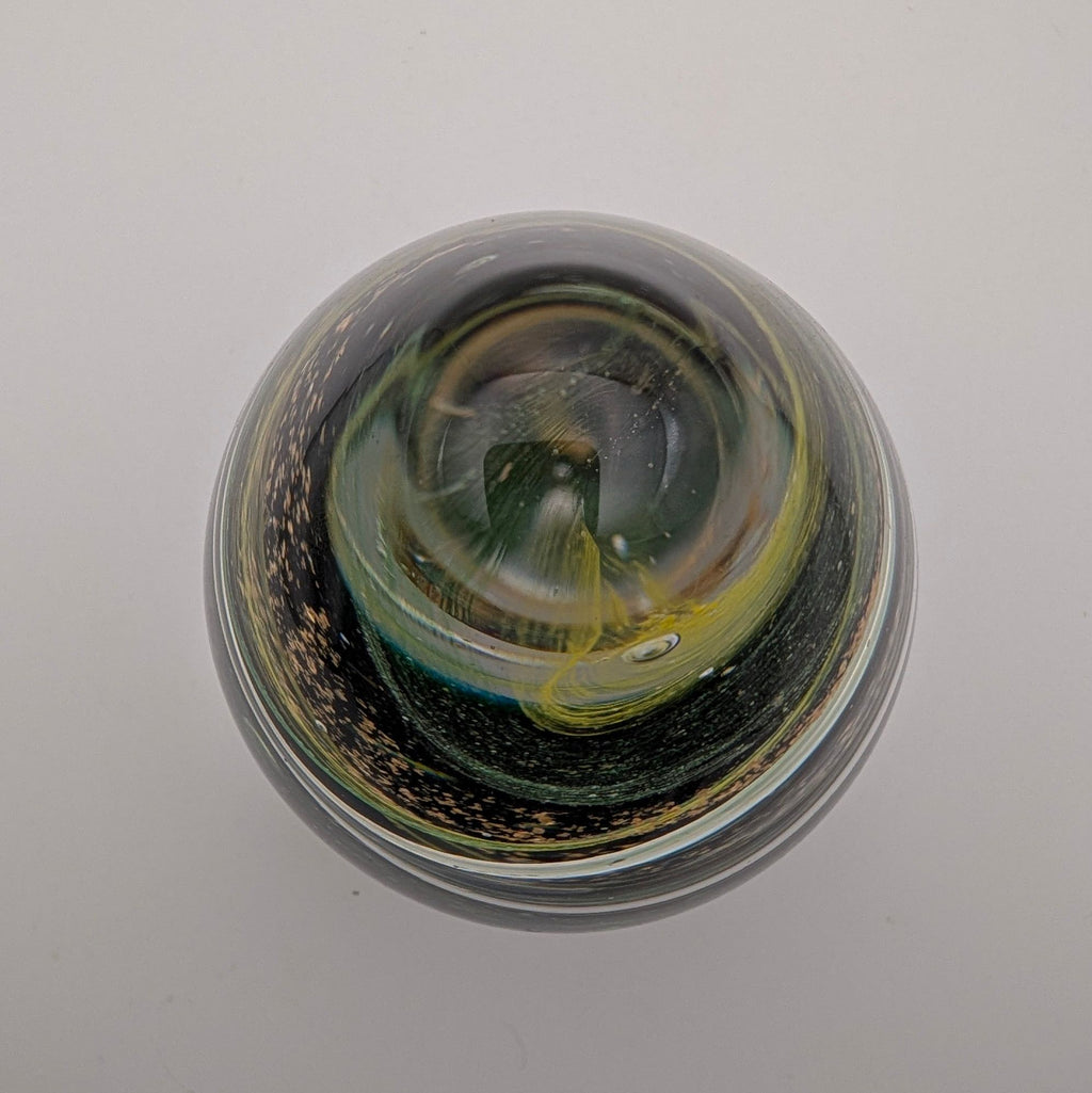 Teardrop glass paperweight, green swirl interior on dark base
