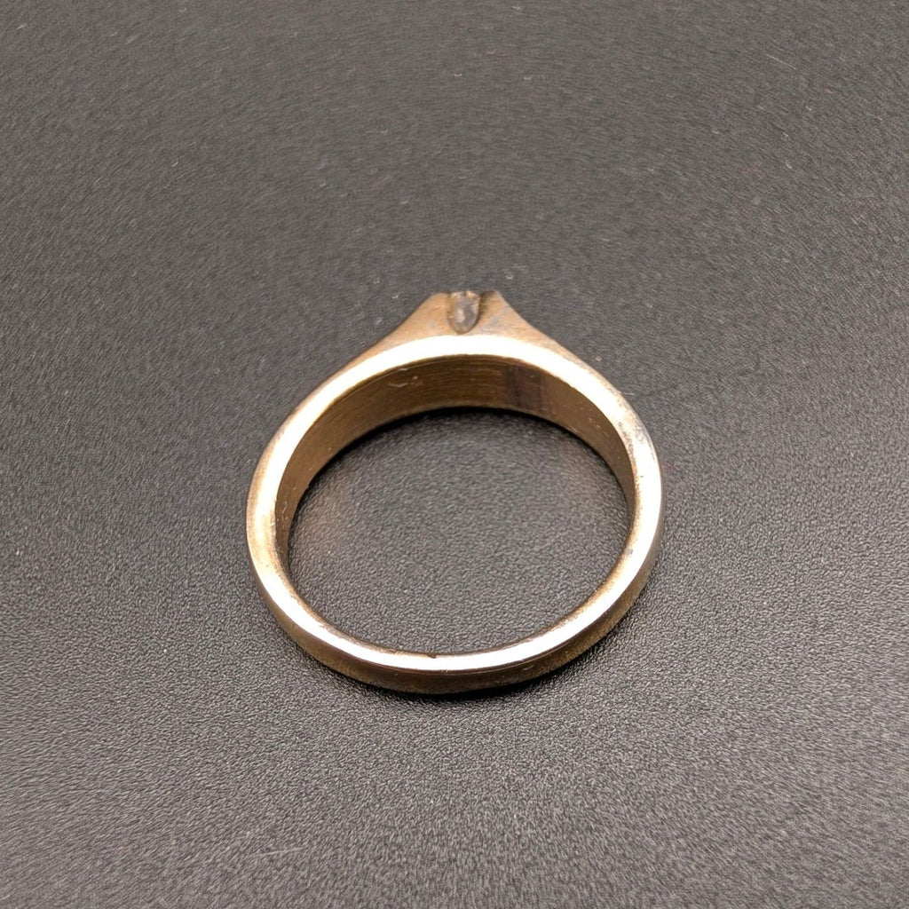 Gold tone solitaire costume ring with small clear rhinestone top view