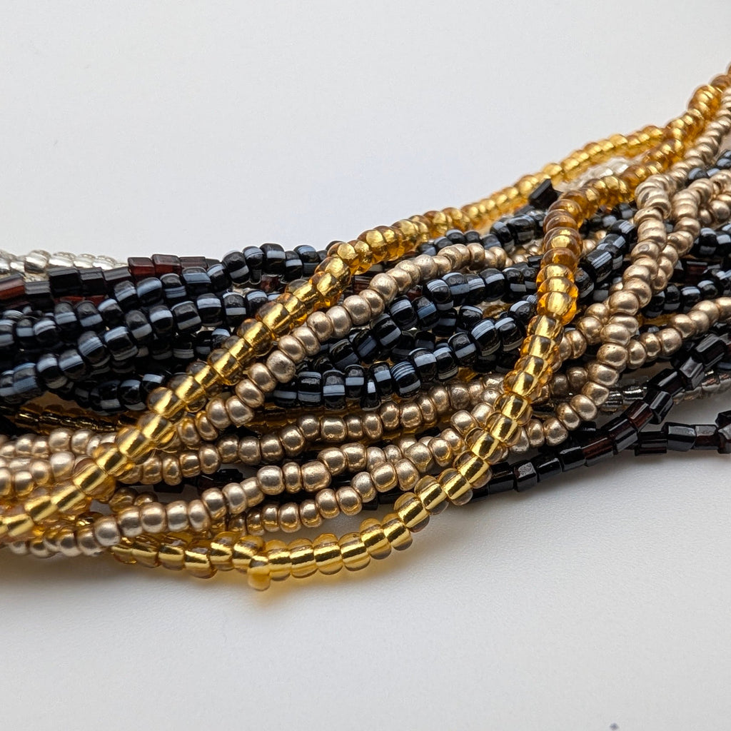 Close-up of fine gold silver black and gunmetal bead strands