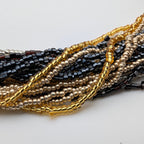 Close-up of fine gold silver black and gunmetal bead strands