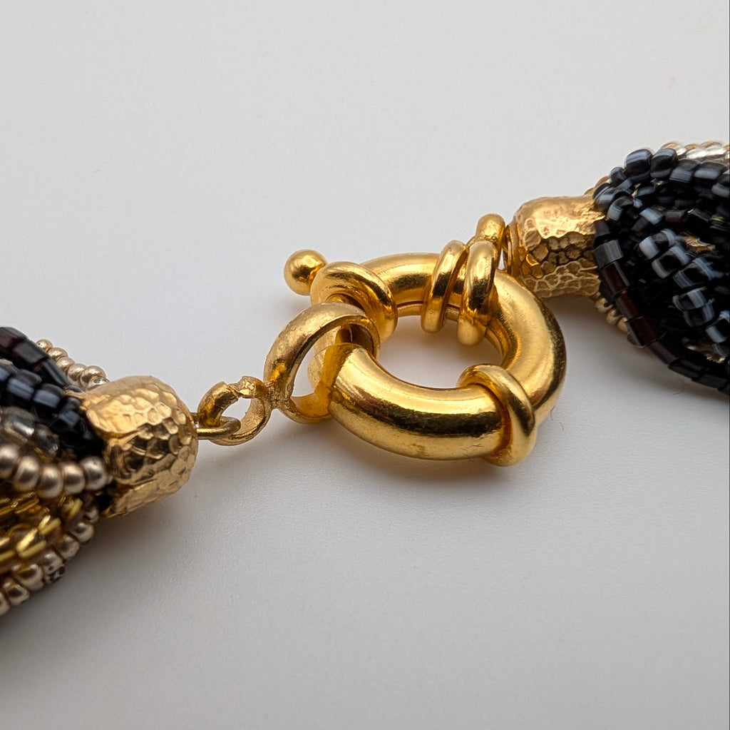 Detailed view of gold-tone clasp connecting rings and end caps showing light surface marks