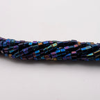 A close-up of a strand of small rectangular iridescent beads on a plain white background.